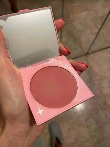 hand showing the inside of the blush container and what the color looks like