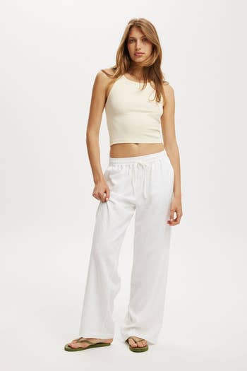 model successful  a sleeveless apical  and relaxed pants standing, modeling casual covering  suitable for shopping