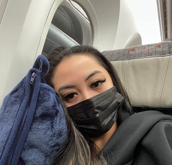 reviewer leaning on blue pillow on a plane