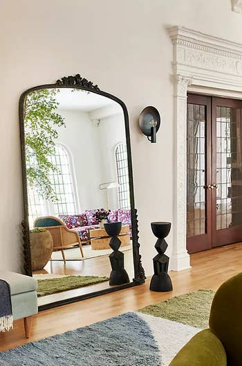 the black full body mirror styled in a home