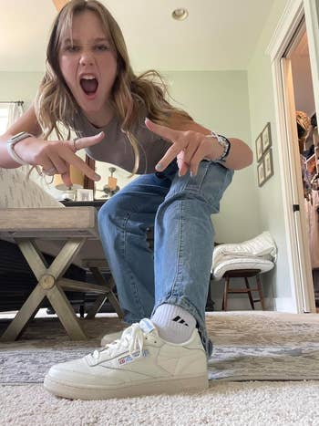 Person successful casual attire, including jeans and sneakers, energetically posing wrong a stylish surviving room, pointing toward the camera