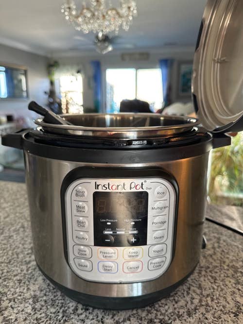 Instant Pot Duo on a kitchen counter, lid open, displaying control panel with various cooking options