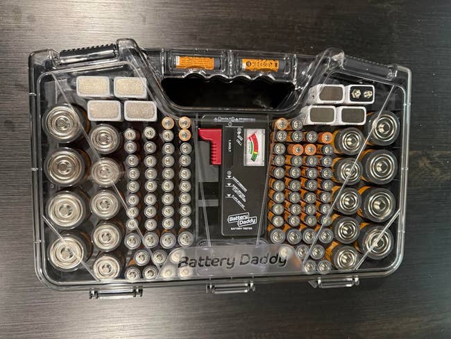 A wide   integrative  artillery  organizer lawsuit  containing assorted  sizes of batteries neatly arranged