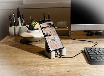 iPhone charging in concrete phone stand on desk