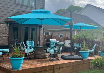 Patio with cushioned chairs, umbrellas, and potted plants connected a woody platform attached to a ceramic house