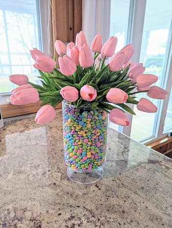 A vase filled with little candies and the flowers