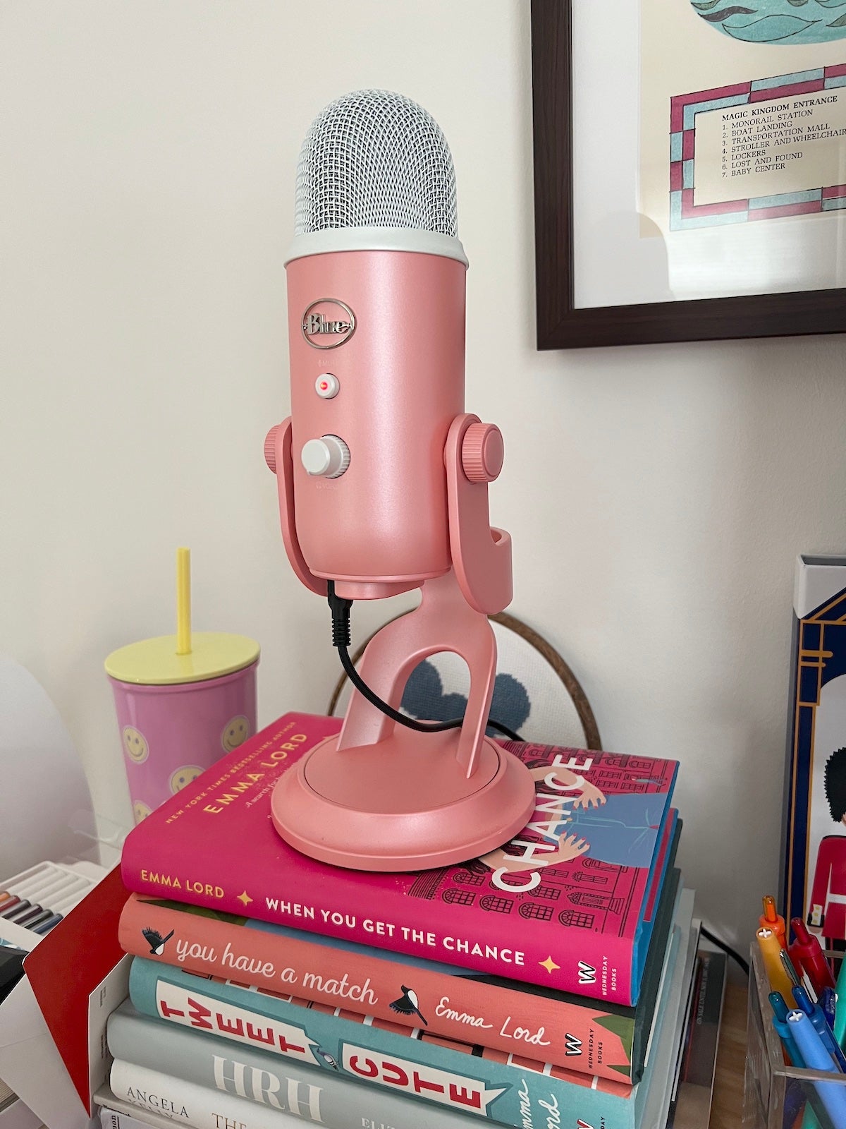a pink microphone on top of a stack of books