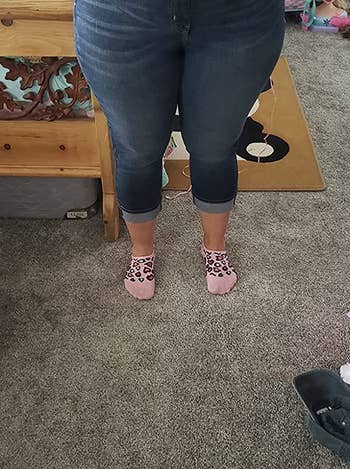 front view of reviewer wearing the cropped jeans with a white cropped sweater and pink leopard print socks
