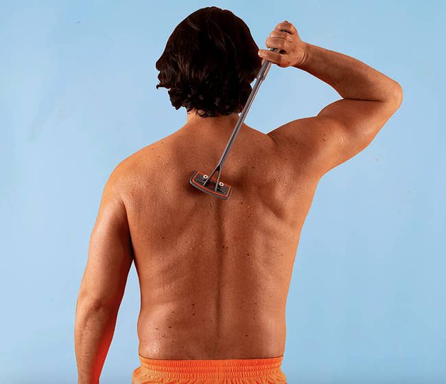 a model using the giant razor to shave their back