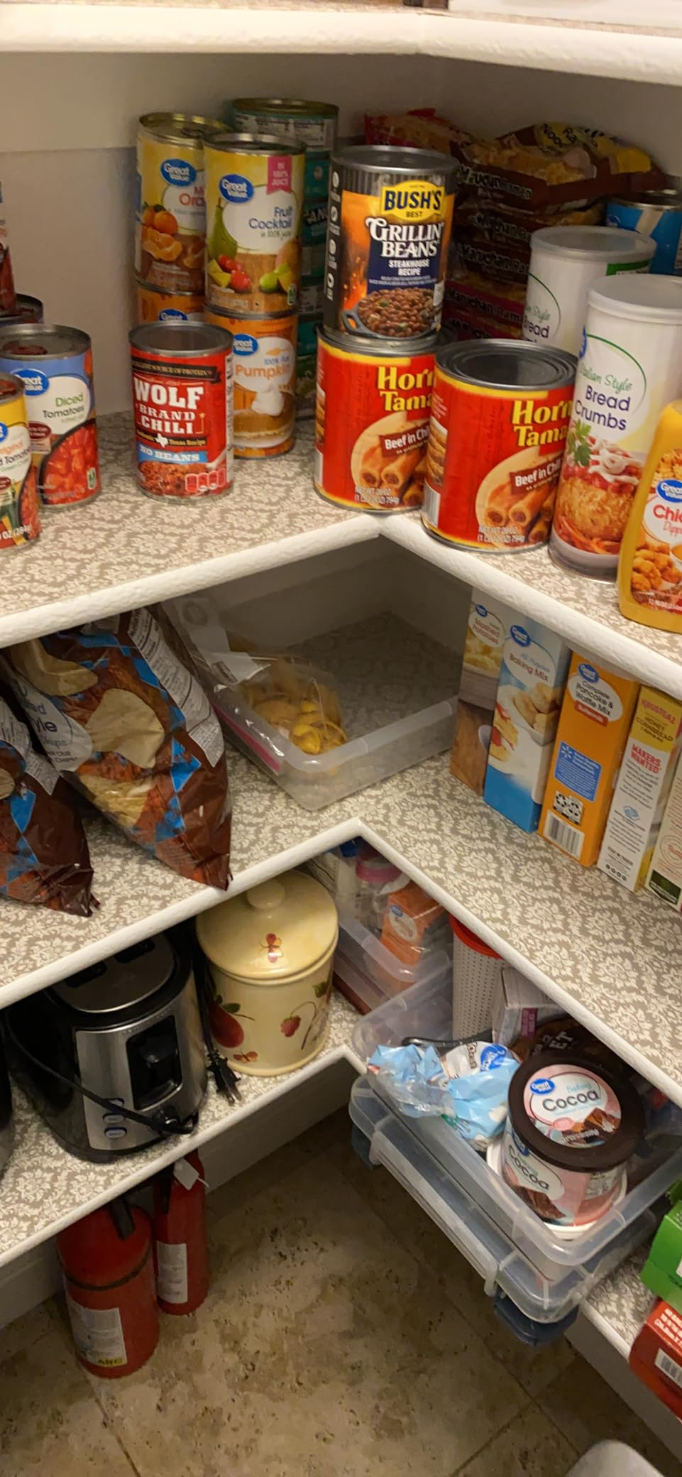 Organized pantry with canned goods, boxes, and snacks neatly arranged connected  shelves, including beans, soups, and chips