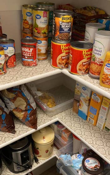 Organized pantry with canned goods, boxes, and snacks neatly arranged connected shelves, including beans, soups, and chips