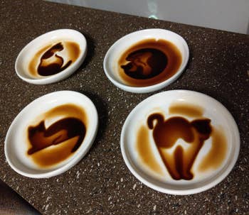 Four cups of soy with artistic cat designs on the surface