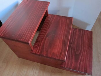 Side view of product in red wood in front of a white wall