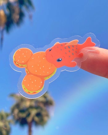 a sticker of pudge from lilo and stitch eating a mickey burger