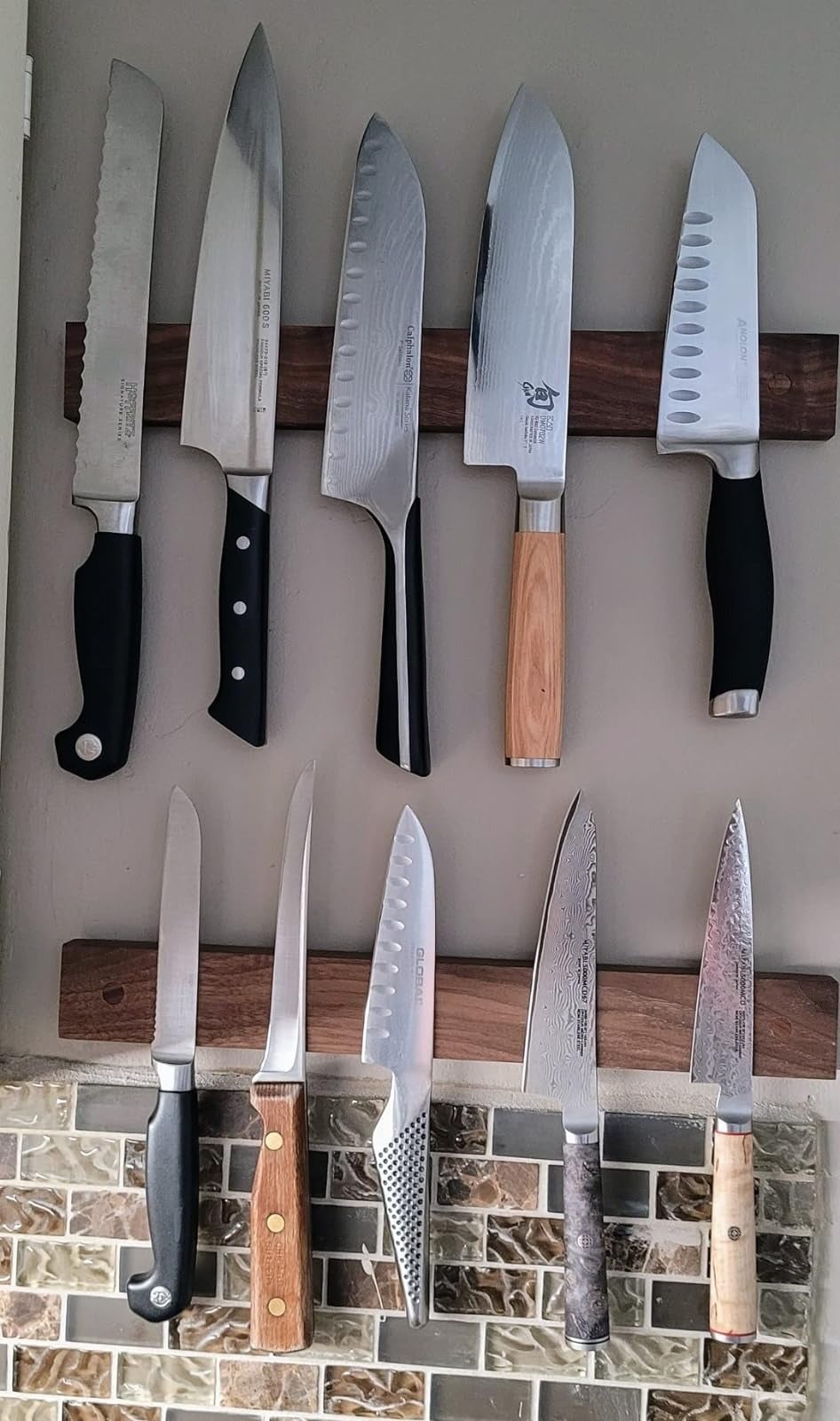Assorted kitchen knives mounted to the wooden strip