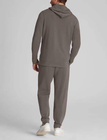 Person in a casual hoodie and sweatpants set, viewed from behind, standing casually, suitable for lounging or casual outings
