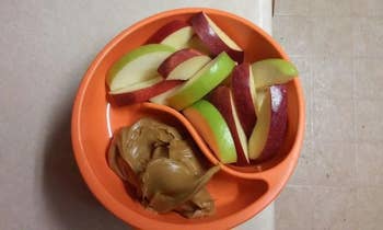 The bowl with apple sliced in one compartment and peanut butter in another
