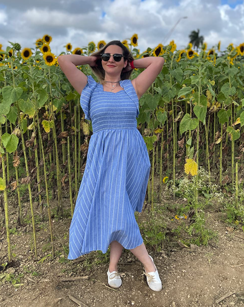 Reviewer in a blue smocked maxi dress with flutter sleeves