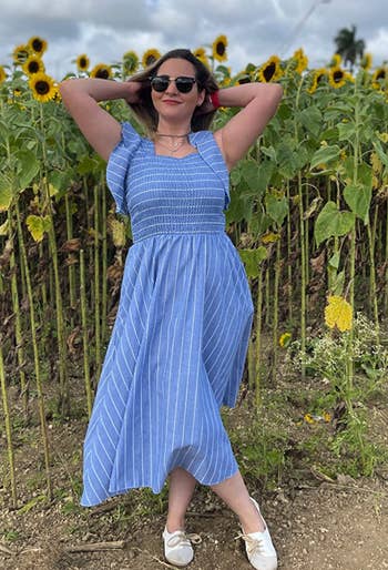 Reviewer in a blue smocked maxi dress with flutter sleeves and white stripes