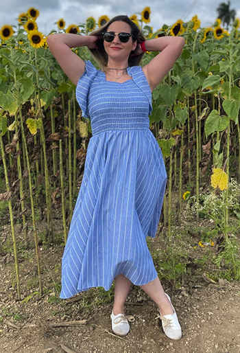 Reviewer in a blue smocked maxi dress with flutter sleeves and white stripes