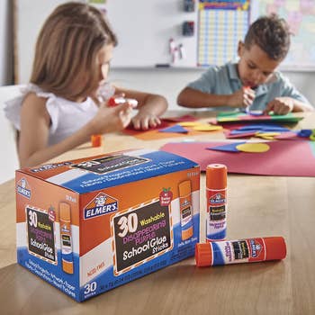 Kids using the pack of glue sticks for a crafting project in a classroom