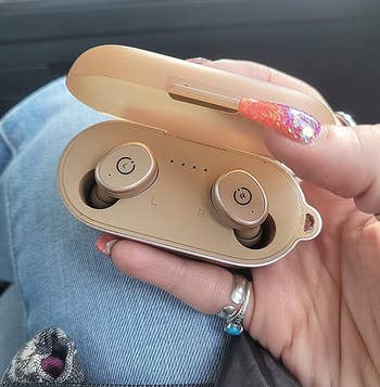 image of same reviewer holding case with earbuds in them