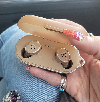 image of same reviewer holding case with earbuds in them