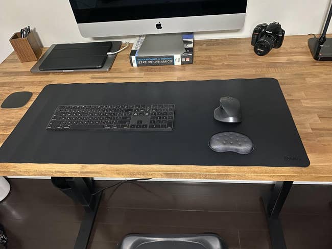 reviewer image of the black heated desk pad on a desk