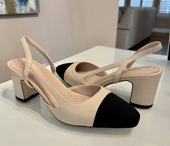 Block-heeled slingback shoes with achromatic toed caps connected a show table