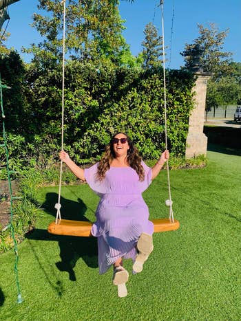BuzzFeed editor wearing the dress in lilac on a swing