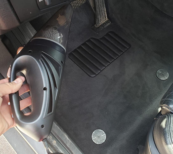 after photo of the same reviewer holding up the vacuum near the car floor, which looks a lot cleaner