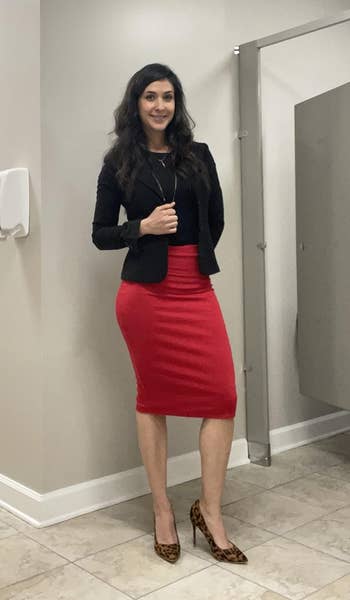 Reviewer in a black jacket, red skirt, and leopard print heels