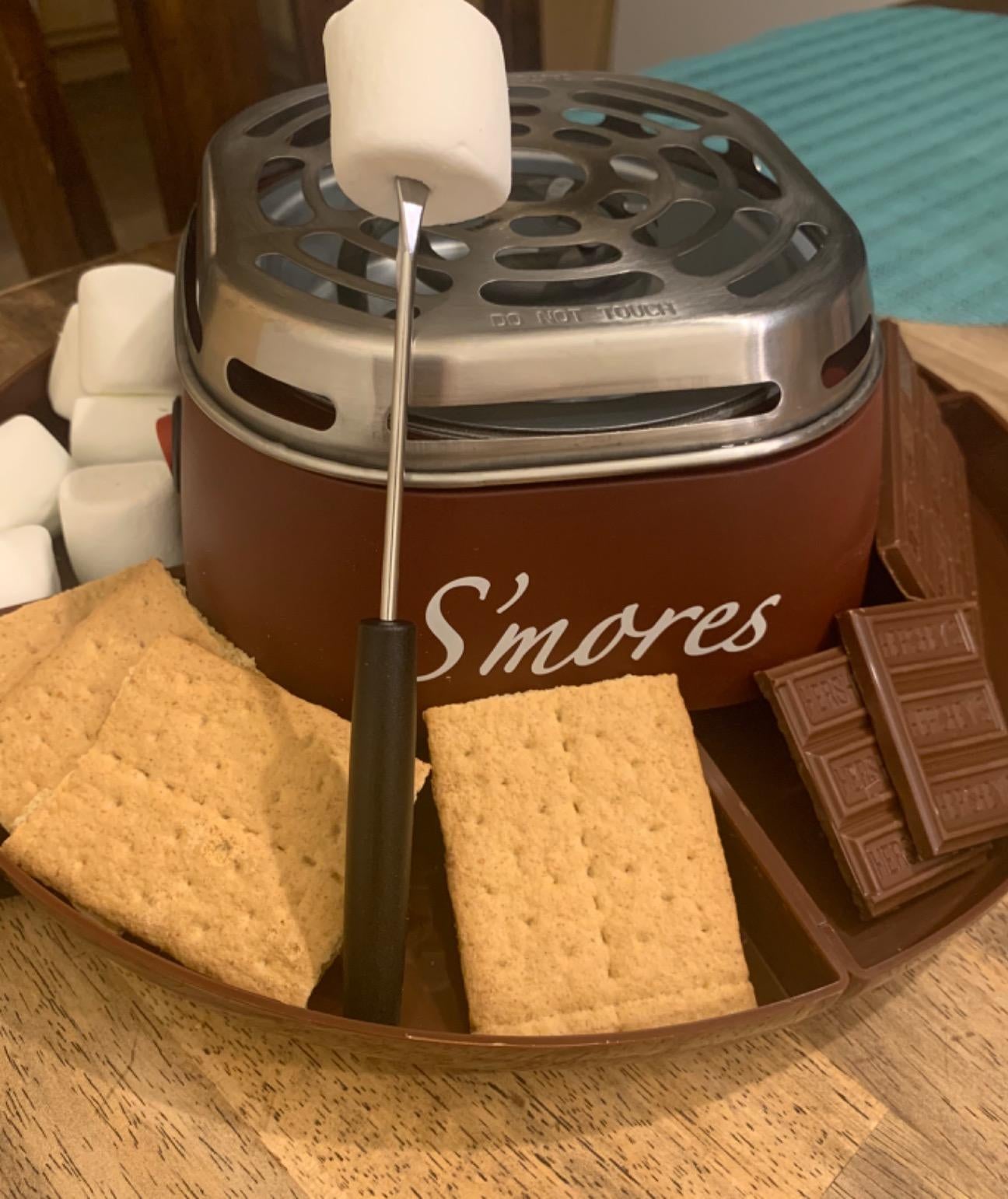 graham crackers, marshmallows, and chocolate around a s'mores grill
