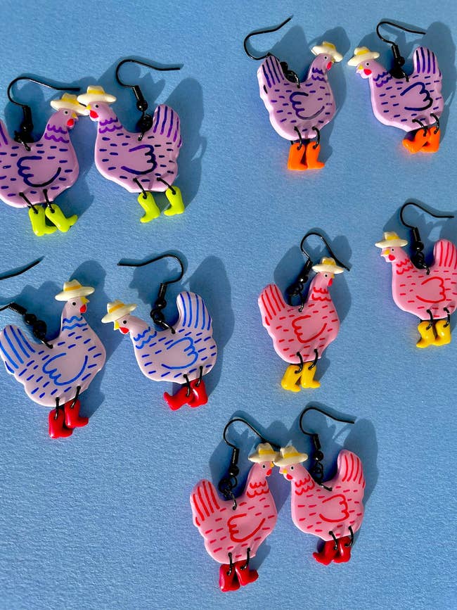 Seven pairs of chicken-shaped earrings successful  antithetic  colors and styles, featuring tiny   hats and boots