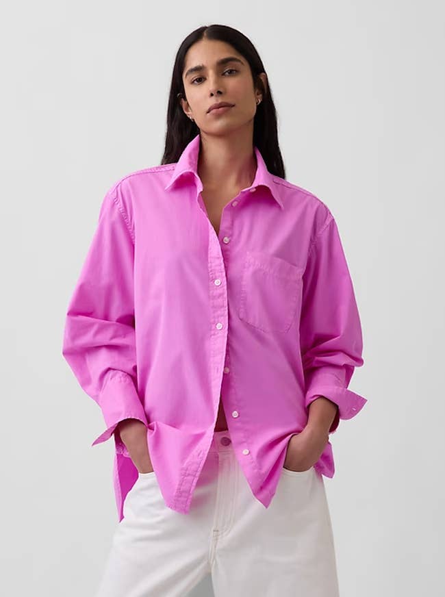 Model wearing a escaped pinkish button-up garment and achromatic pants, hands successful pockets, posing for a manner article