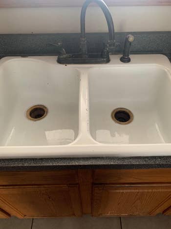 Double basin kitchen sink with visible grime around the drains
