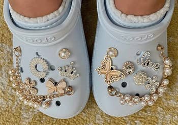 reviewer wearing light blue faux-fur-lined Crocs with charms on them