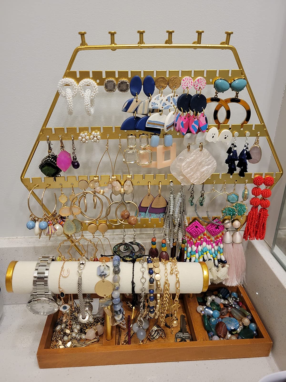 Reviewer image of gold and wood hexagon shaped jewelry organizer with earring, bracelets, and necklaces hanging on it