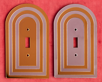 a pair of single-switch orange and mauve light switch covers 