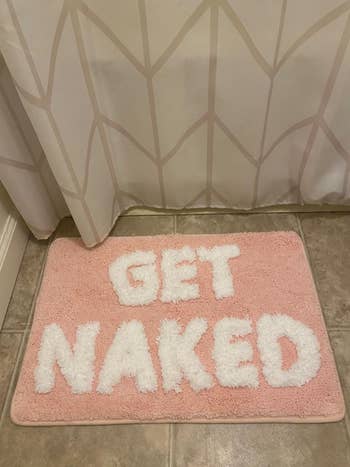 A humorous bathroom mat with the phrase 