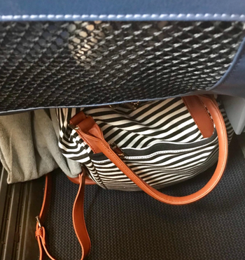 the weekender bag under an airplane seat