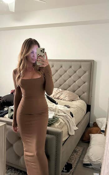 reviewer posing in long brown dress