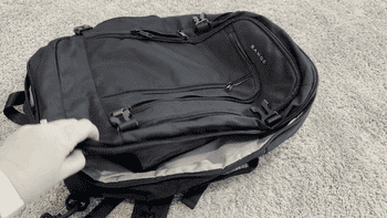 a BuzzFeed writer opening the back pack to show that it comes completely undone for easy access