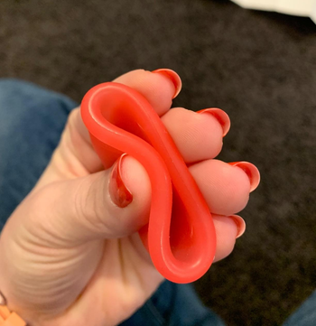 image of reviewer squeezing the pink menstrual cup