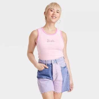 a model in a pink cropped tank with the barbie logo in the middle