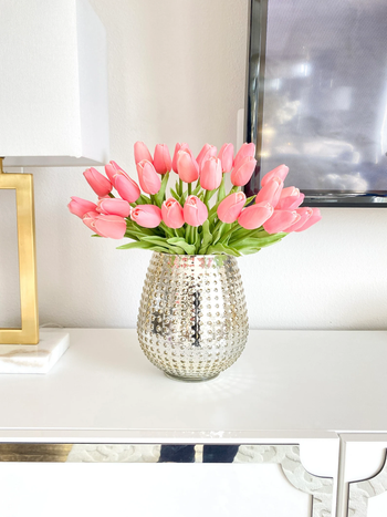 a bunch of pink fake tulips in a vase