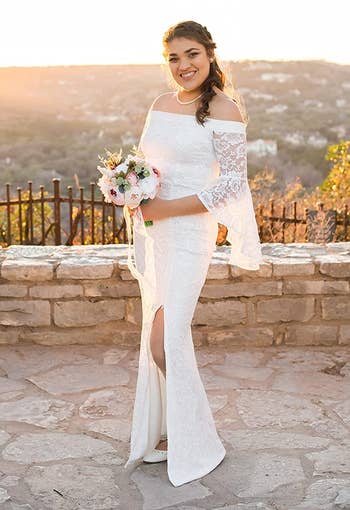 Reviewer wearing product showing side view while holding bouquet in front of mountain landscape