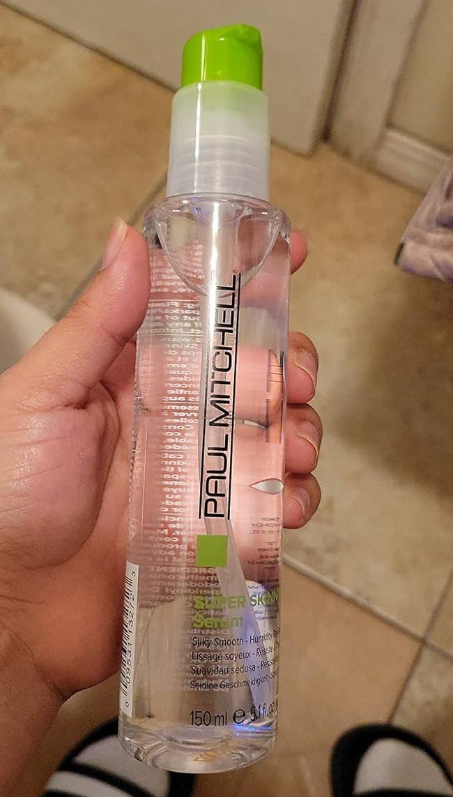 reviewer holding a bottle of Paul Mitchell serum