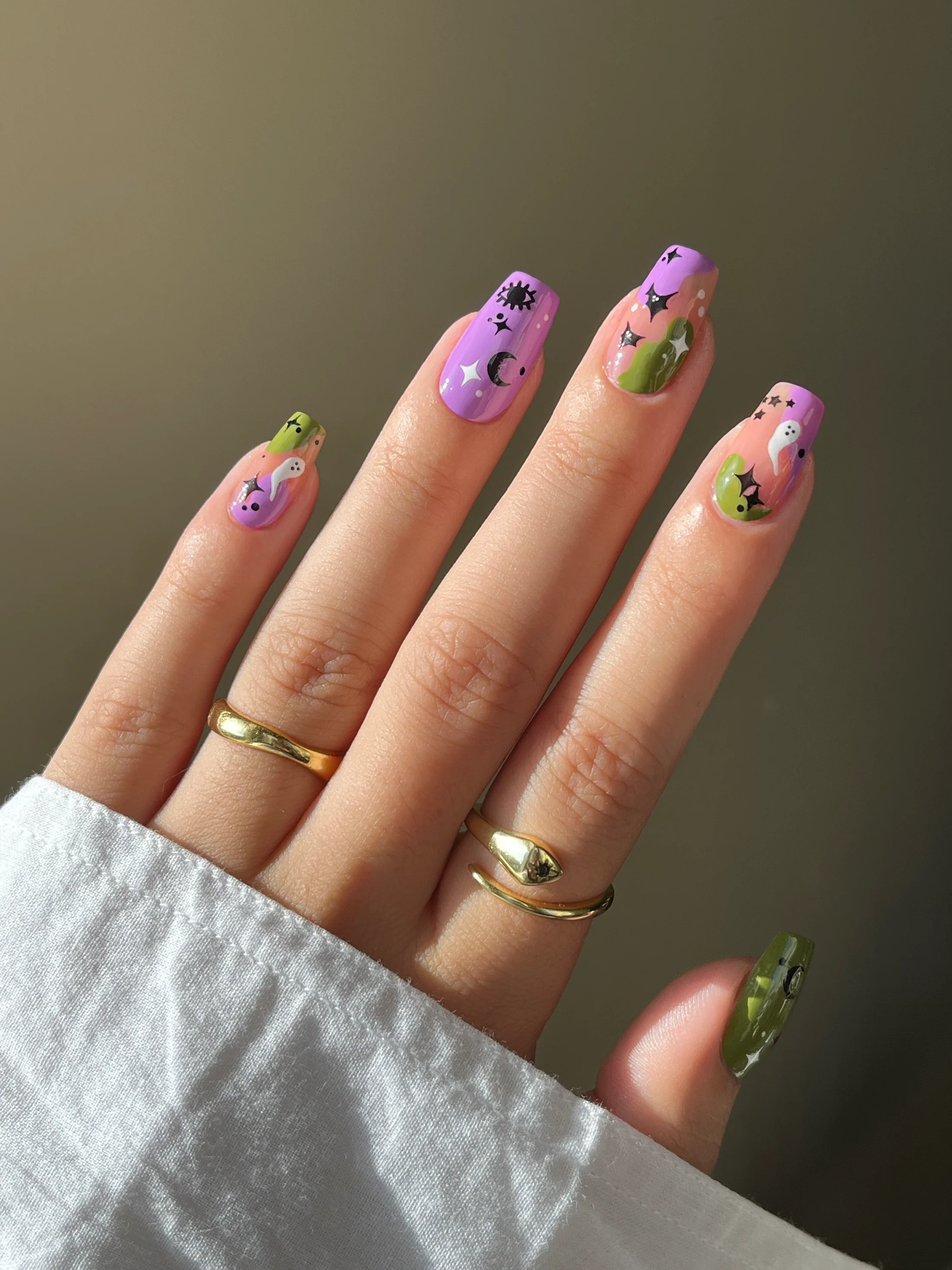 Manicured manus  with playful nail art, including stars, moons, faces, and abstract patterns