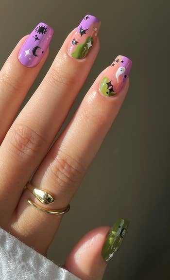 Manicured manus with playful nail art, including stars, moons, faces, and abstract patterns